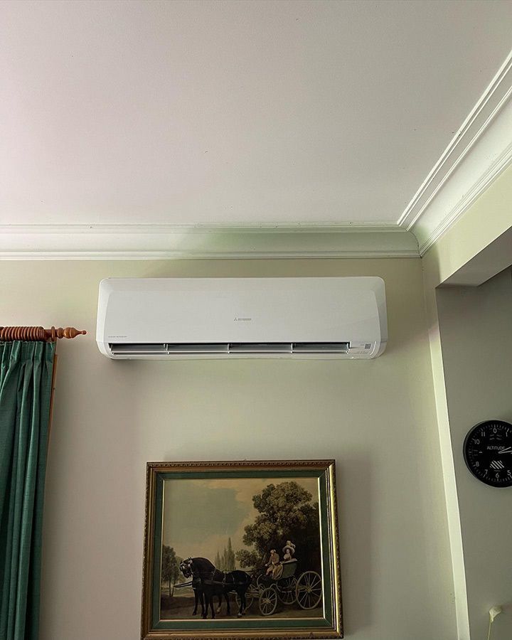 There Is A Picture Of A Horse Drawn Carriage On The Wall Above The Air Conditioner — Priest Airconditioning in Ashmont, NSW