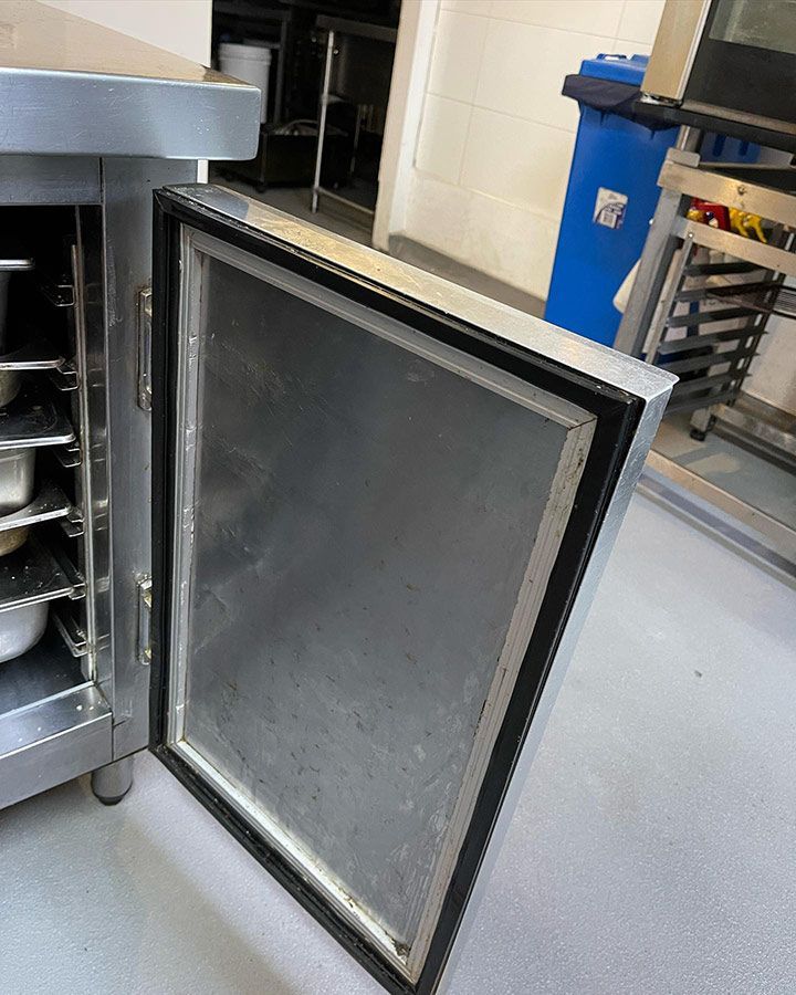 A Stainless Steel Cabinet With The Door Open And A Blue Trash Can In The Background — Priest Airconditioning in Ashmont, NSW