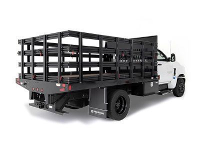 A white truck with a black fence on the back of it.