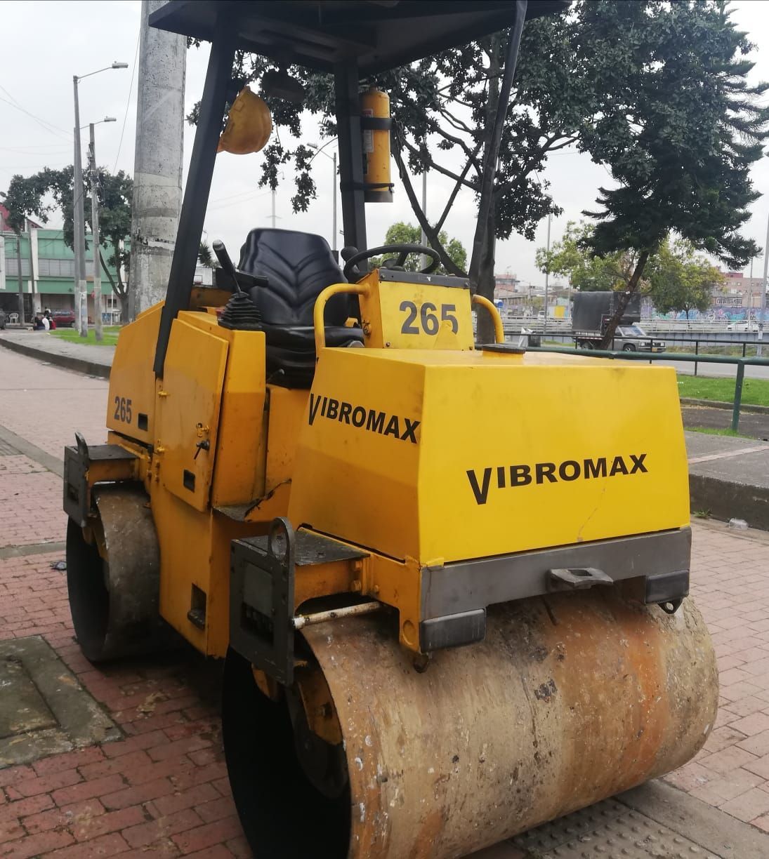 Un rodillo compactador Vibramax amarillo está estacionado en una acera