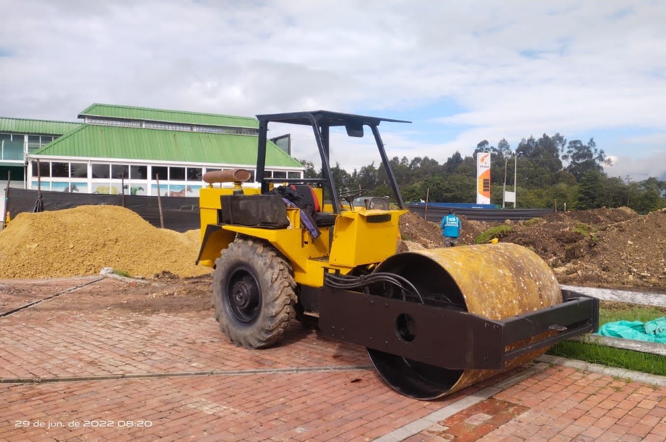 Un vehículo de construcción amarillo está estacionado frente a un edificio.