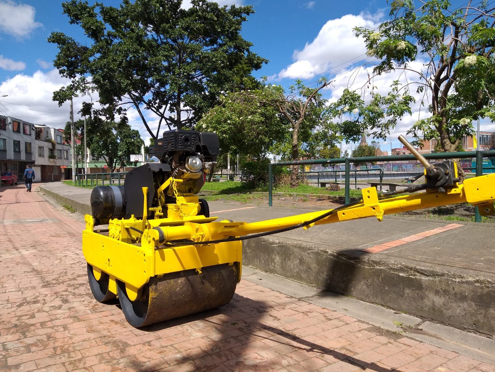 Un rodillo amarillo está estacionado al costado de la carretera.