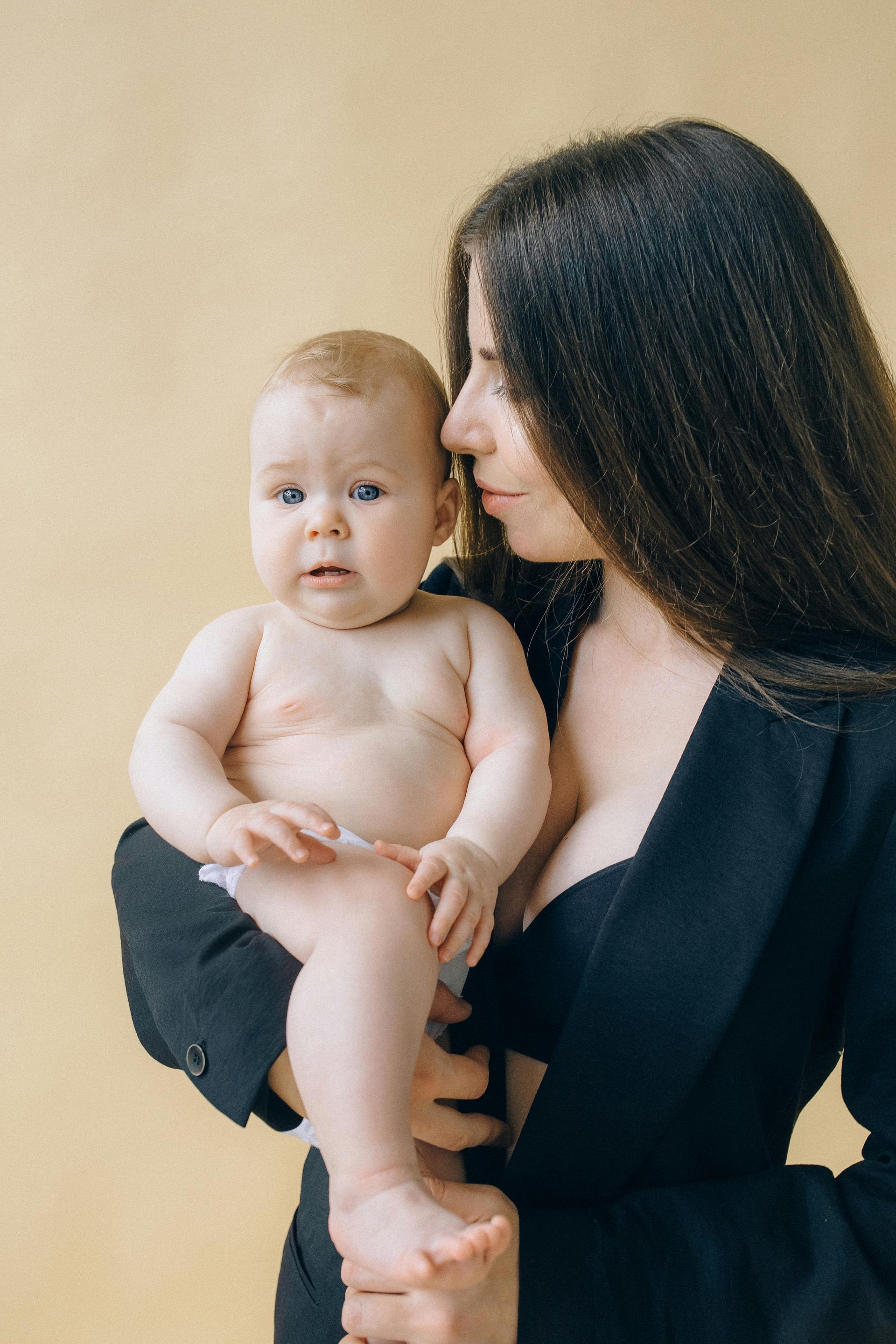 A woman is holding a baby in her arms.