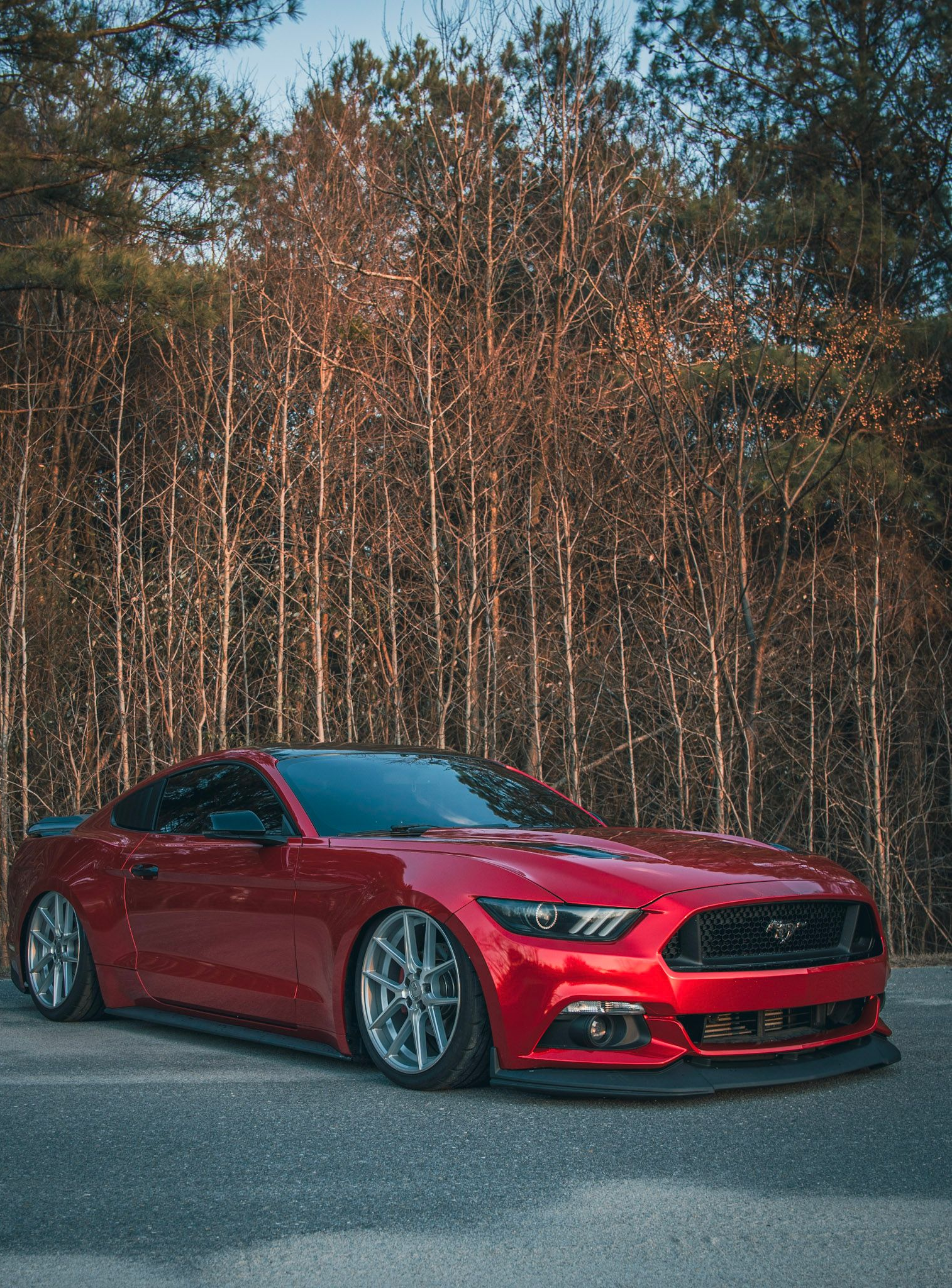 Light blue Subaru WRX with black wheels and a hood scoop, parked on asphalt.
