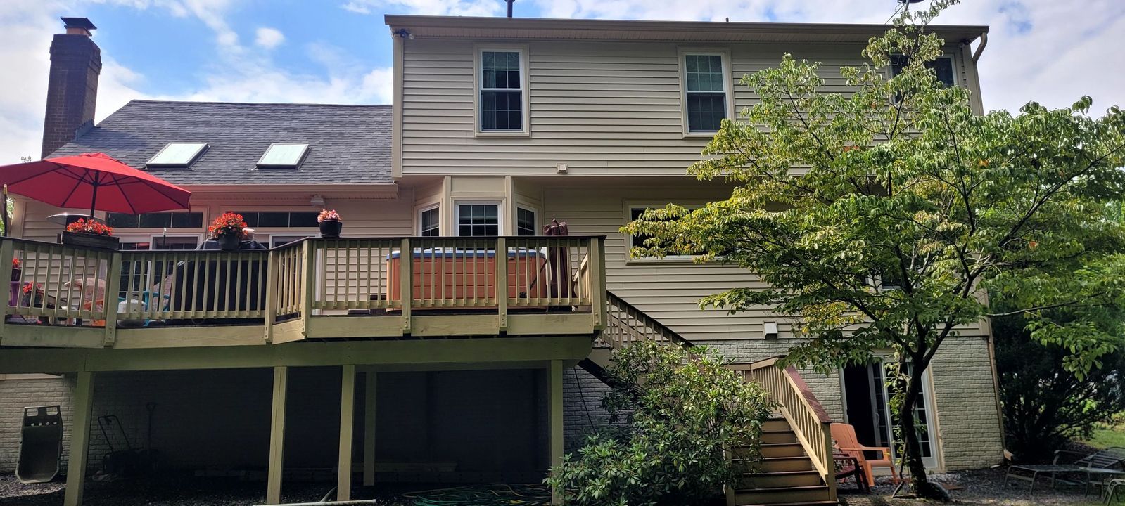The back of a house with a large deck and stairs.