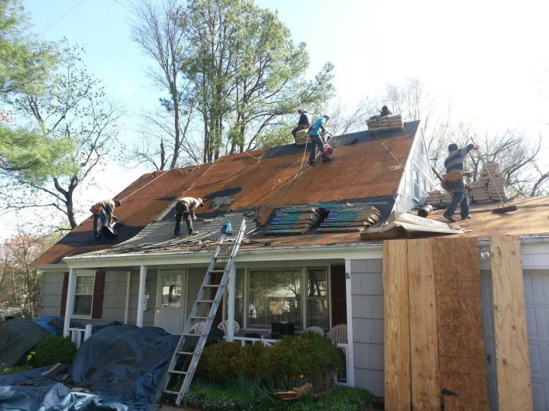 a group of people are working on the roof of a house