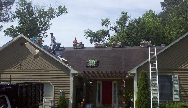 a group of people are working on the roof of a house