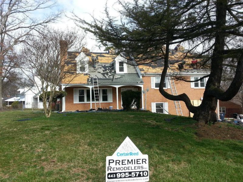 a house with a premier remodelers sign in front of it