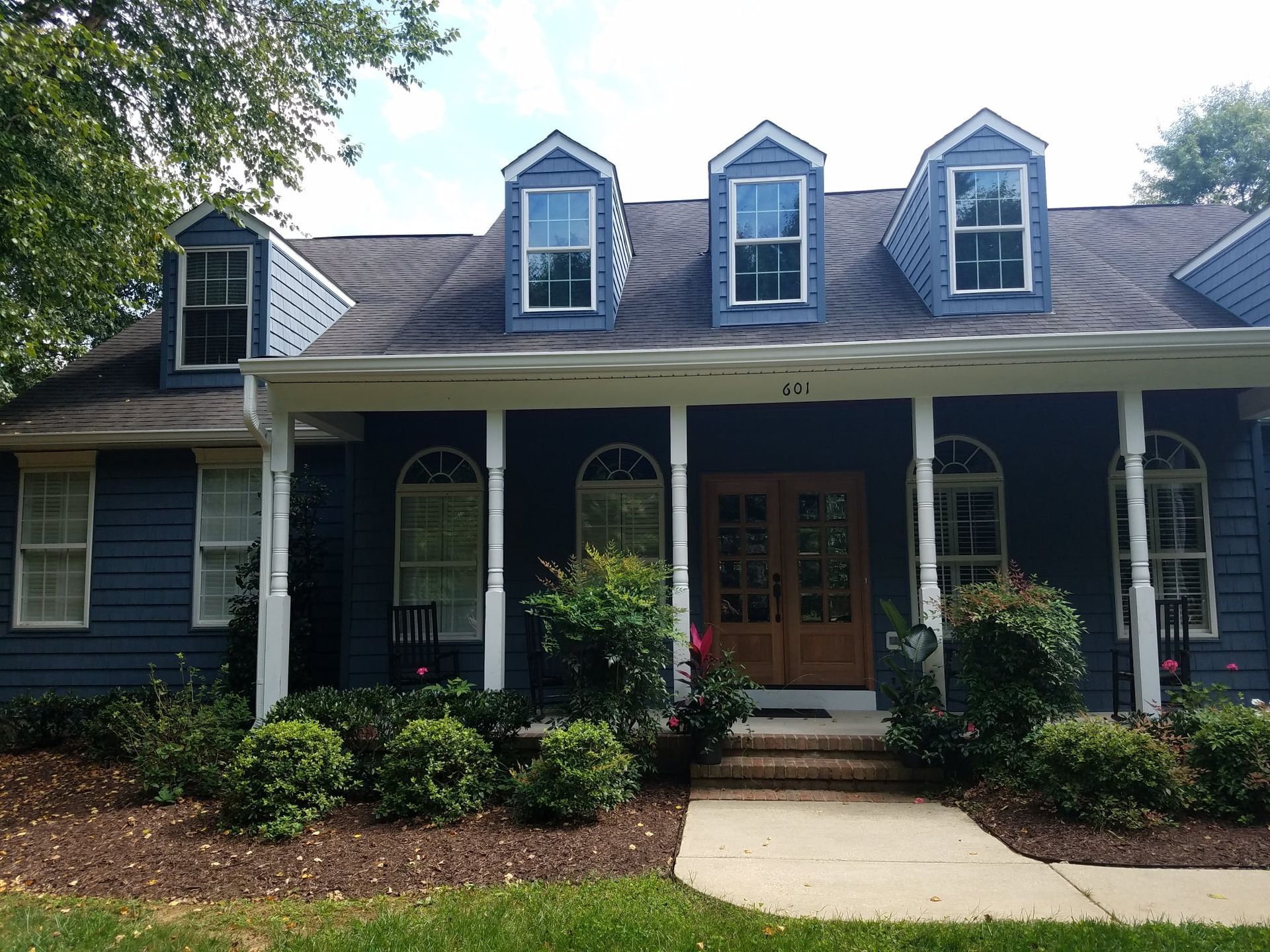A blue house with a porch and a roof