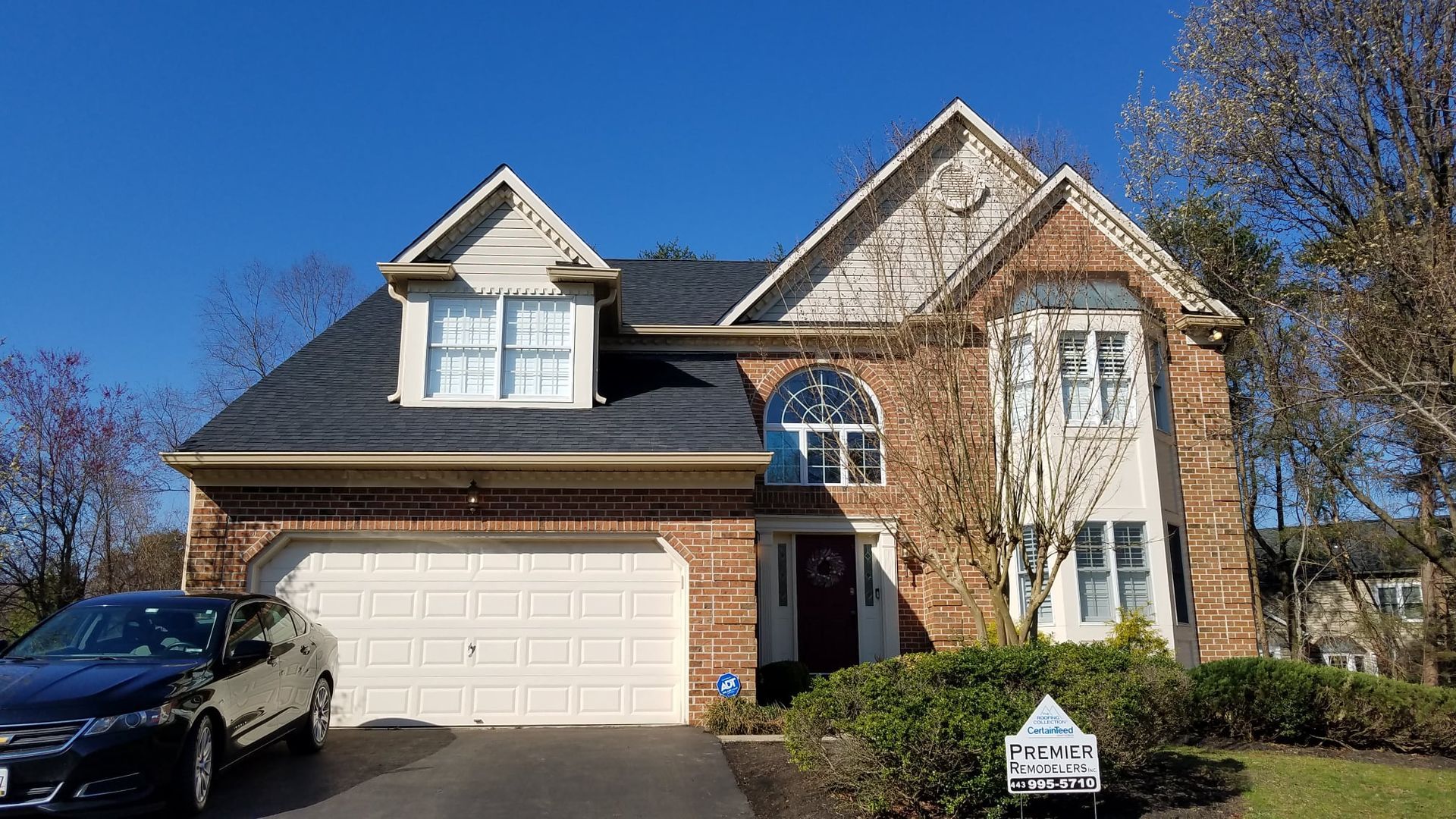 A large brick house with a car parked in front of it.