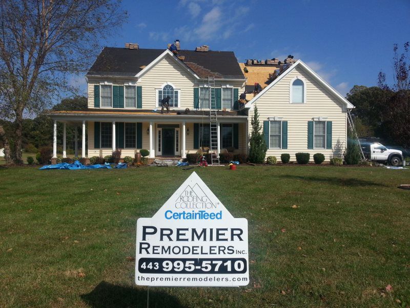 a sign for premier remodelers is in front of a house