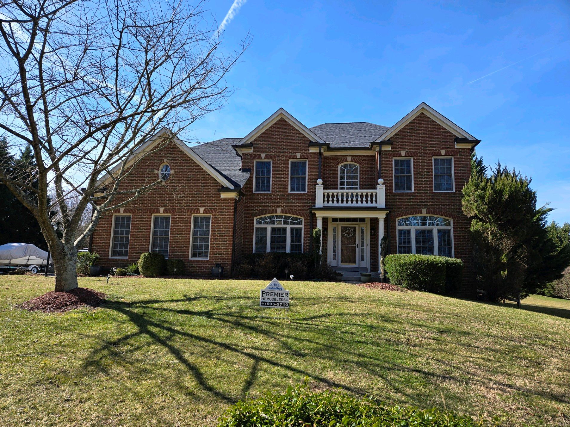 A large brick house with a large lawn in front of it.