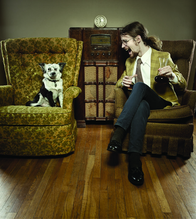 A man is sitting in a chair next to a dog