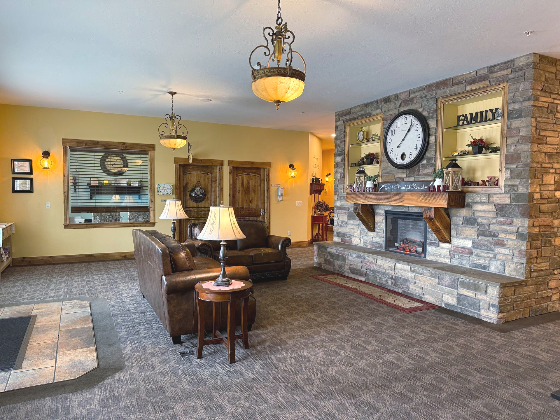 Cozy living room with stone fireplace, leather furniture, and warm lighting.