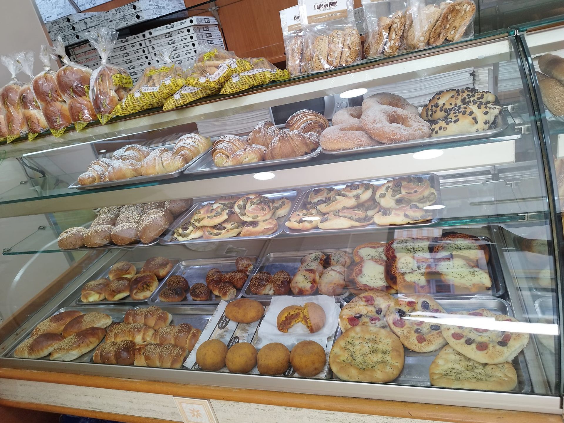 Una vetrina piena di una varietà di dolci e pani.