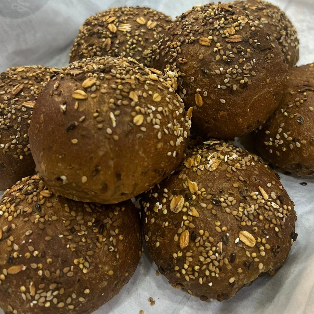 Un mucchio di palline di pane con semi di sesamo sopra