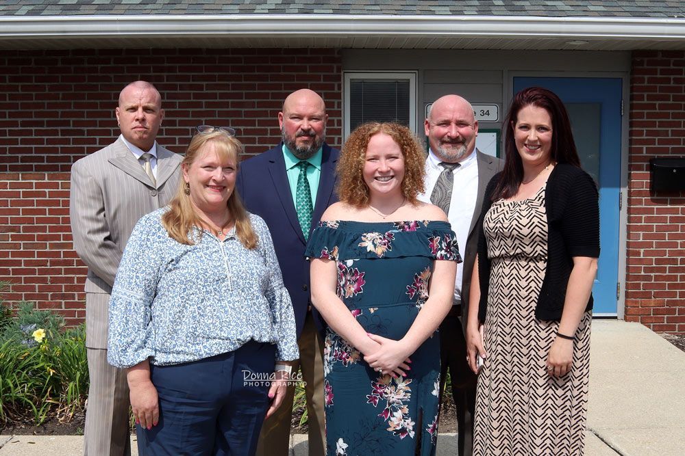 A group of people from Accentus Health are posing for a picture in front of a brick building.