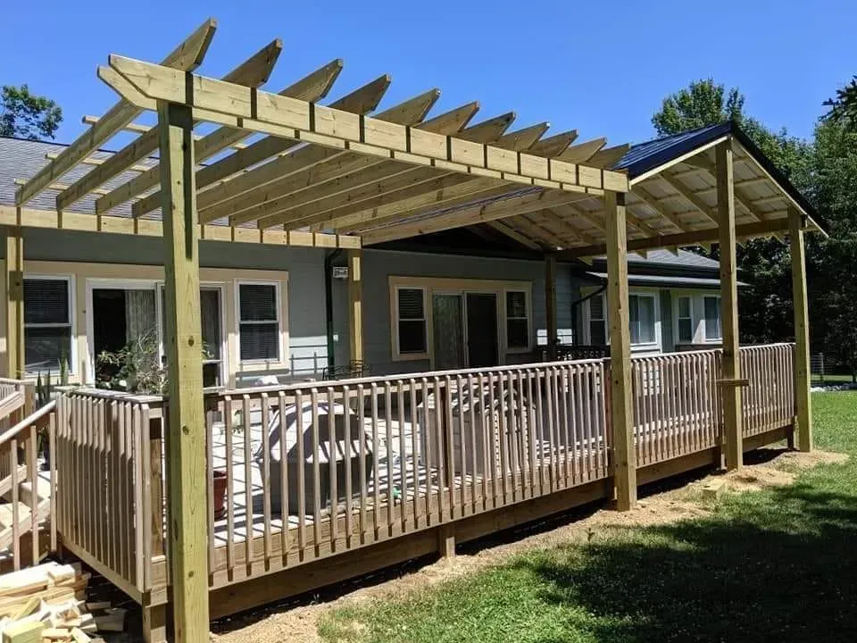 A wooden deck with a pergola on top of it