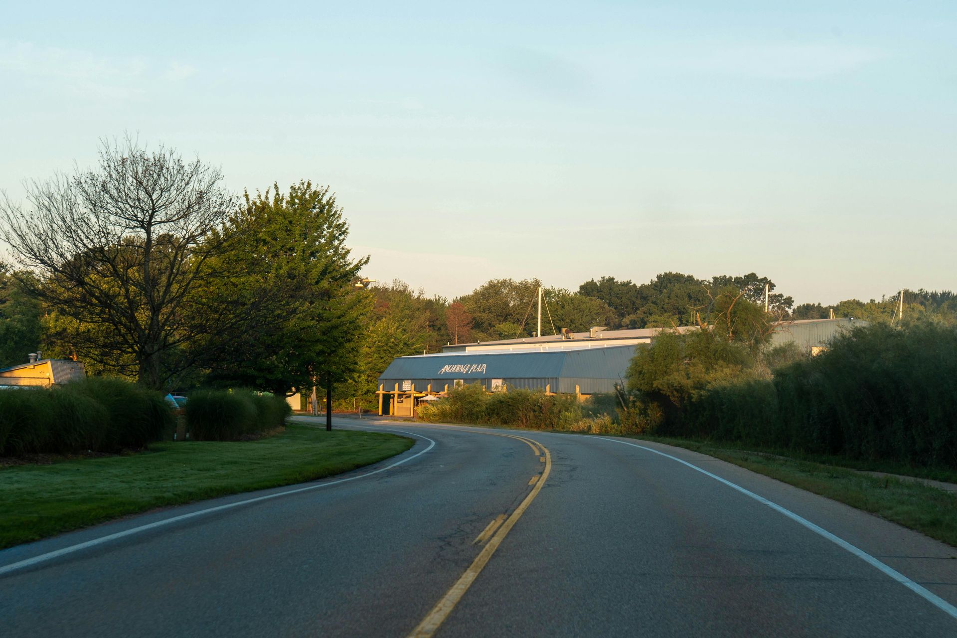Paved road curves towards a building with a large
