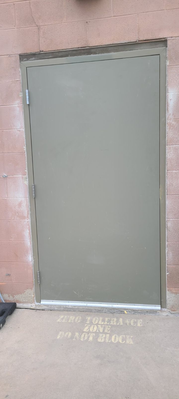 A door is sitting on the side of a building next to a brick wall.