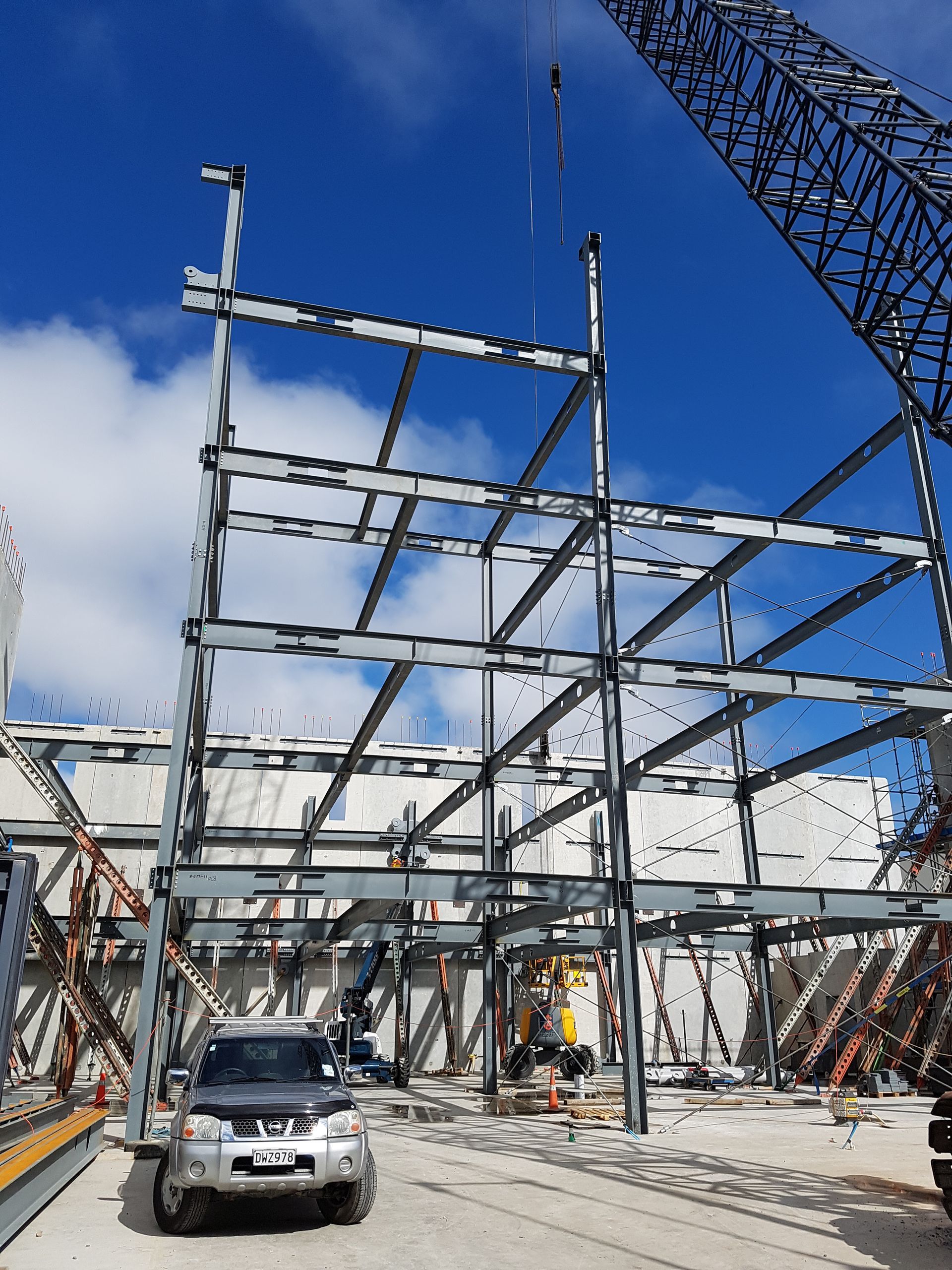 A car is parked in front of a building under construction