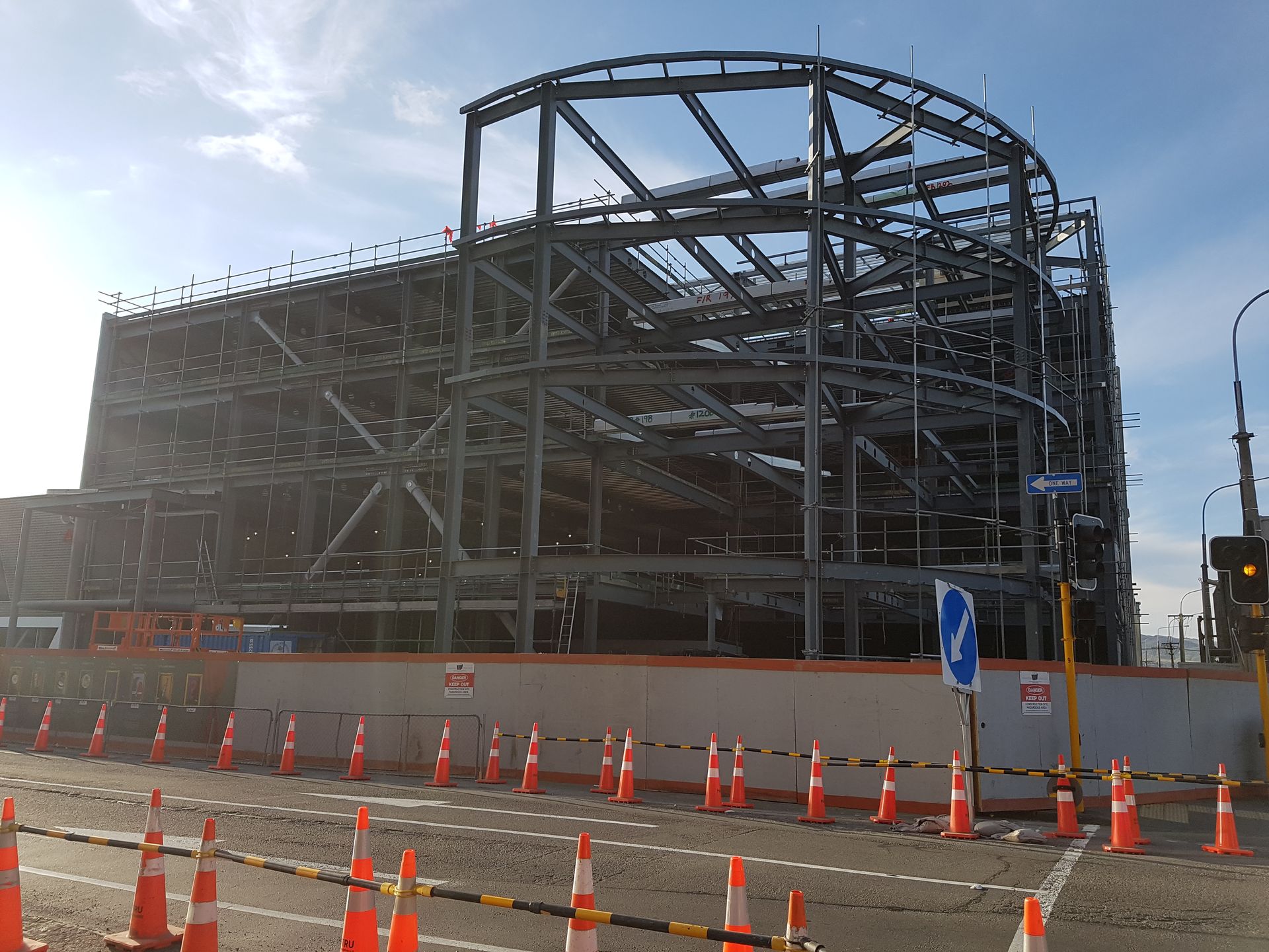 A large metal structure is being built on the side of a road.