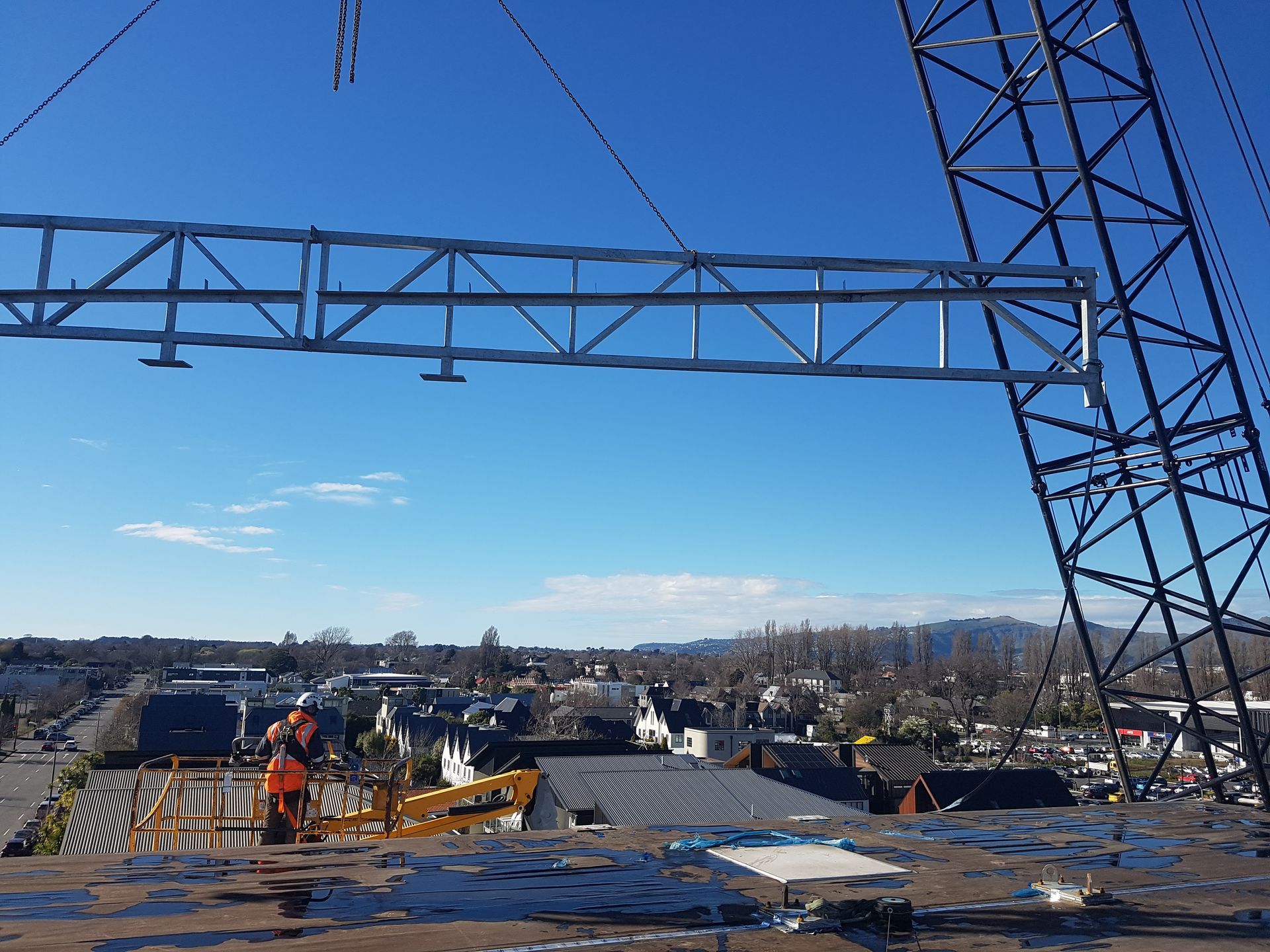 A crane is lifting a metal structure on top of a building.