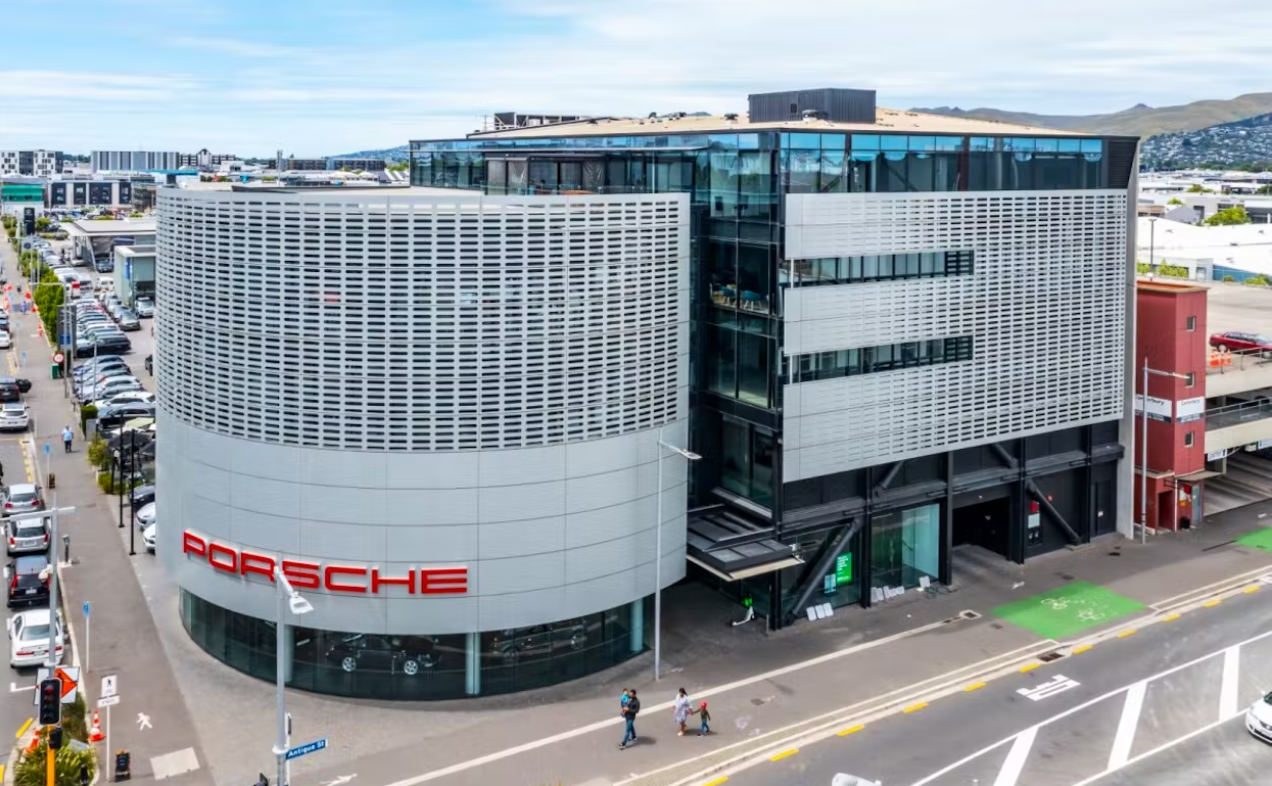 An aerial view of a large porsche building on a city street.