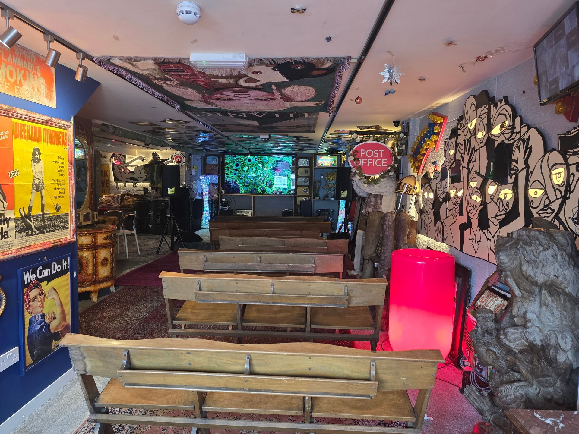 Graffiti-covered bar interior with wooden benches, neon lights, and a pink glowing booth