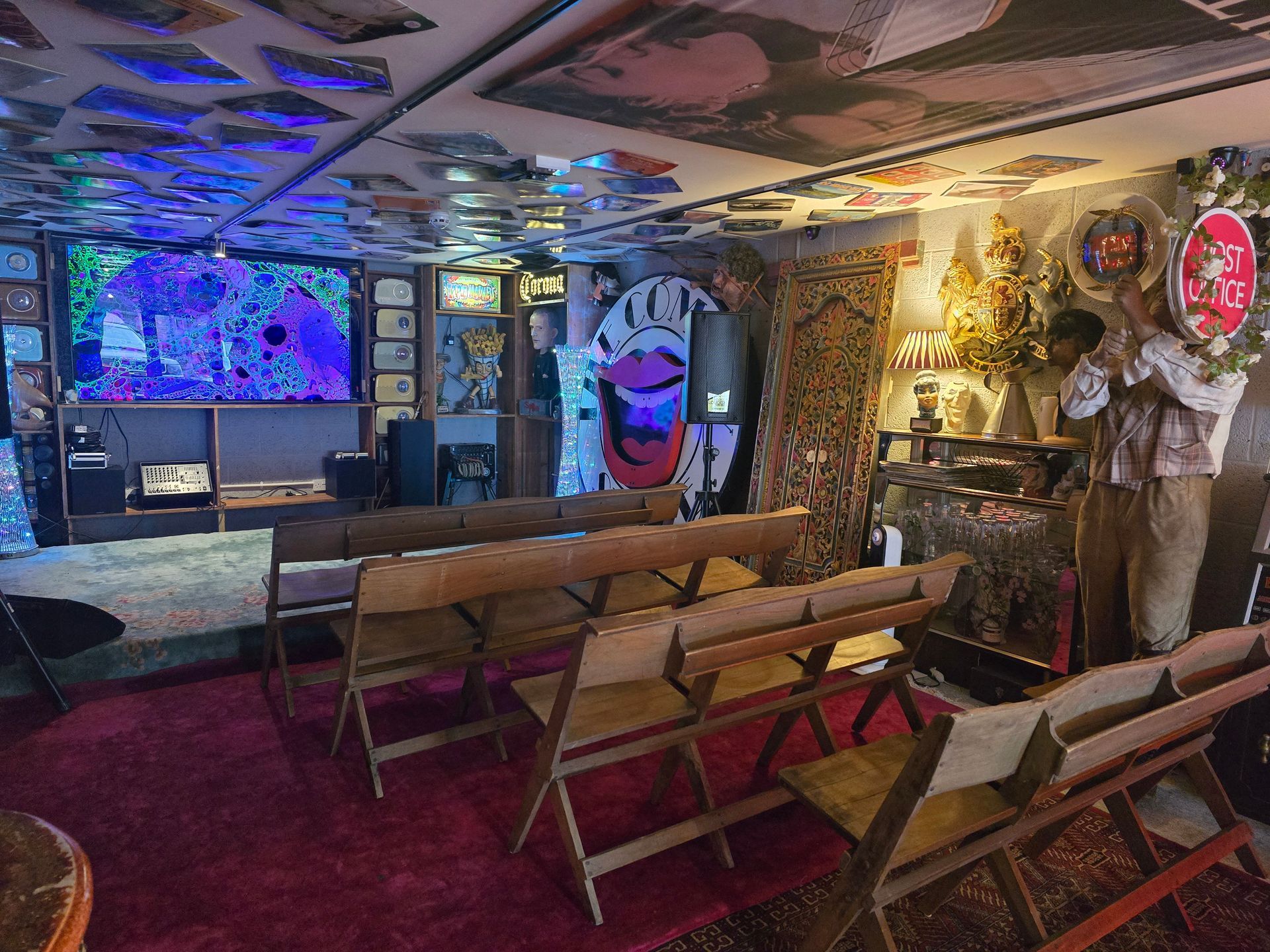 Colorful neon-lit lounge with folding chairs, benches, and a glowing fish-shaped wall decoration