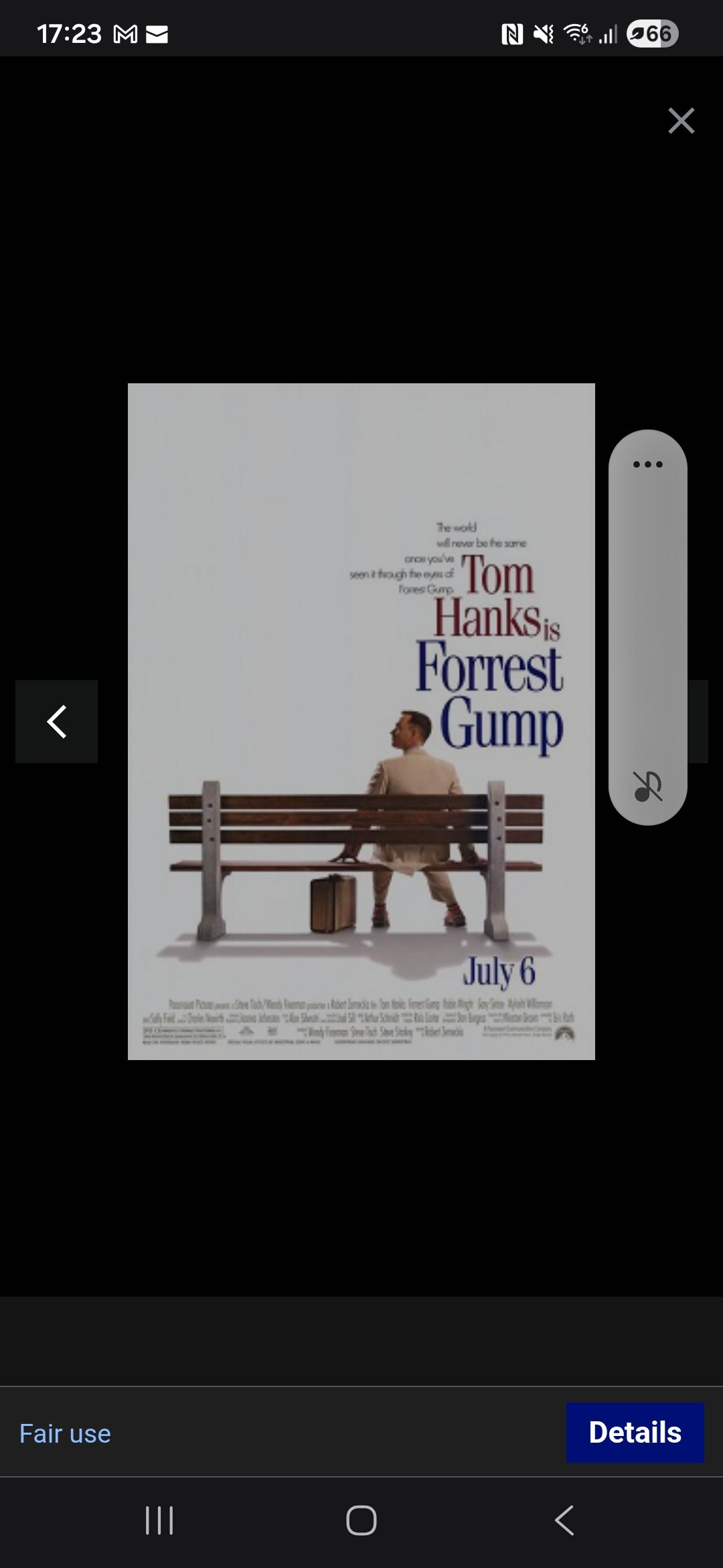 Forest Gump poster on a phone screen, showing a man sitting on a bench with a suitcase beside him.