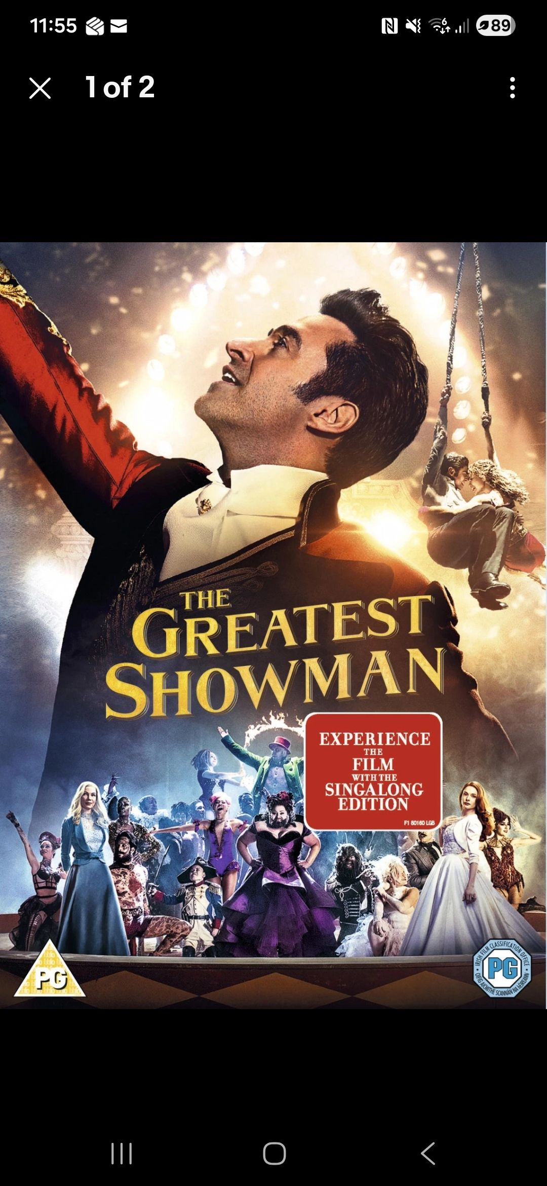 Movie poster for The Greatest Showman, featuring Hugh Jackman with arms raised amid a glowing circus scene.