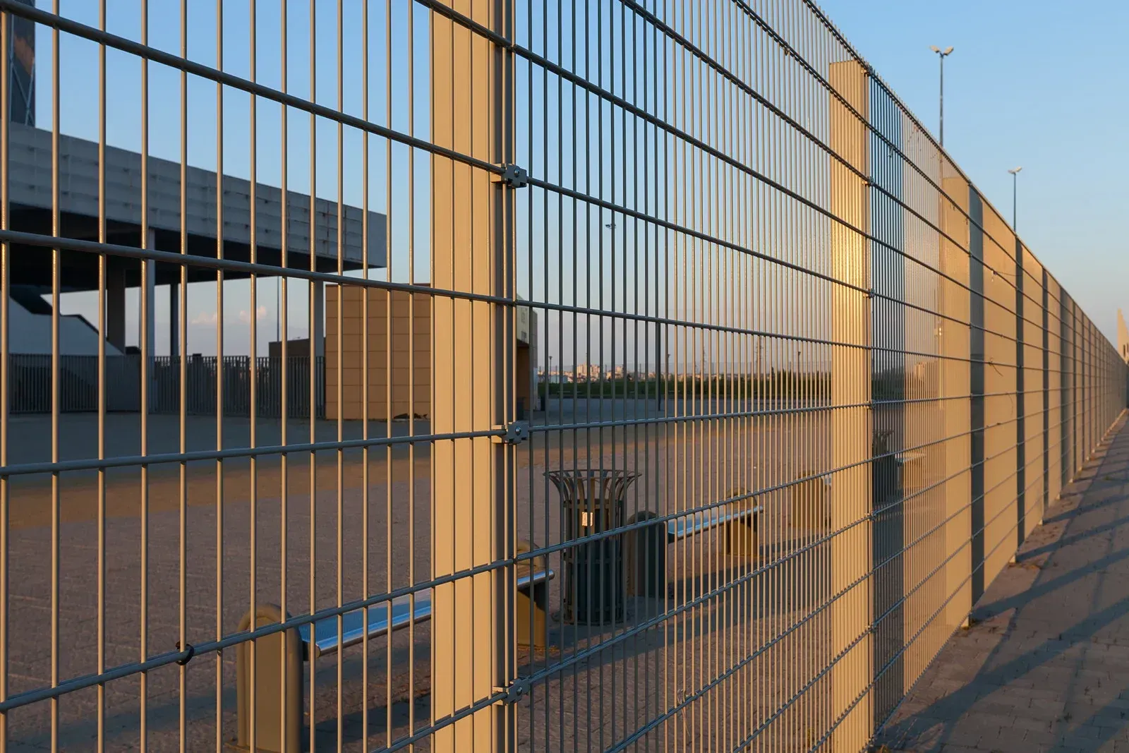 A long fence with a bridge in the background