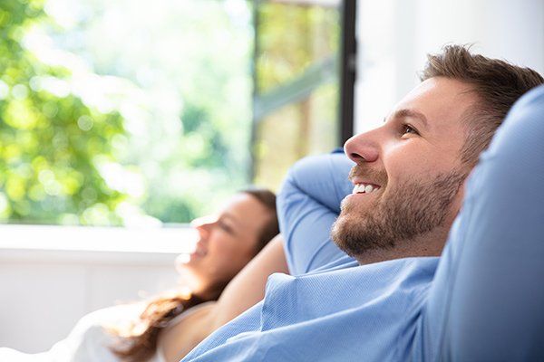 man and woman relaxing with window open