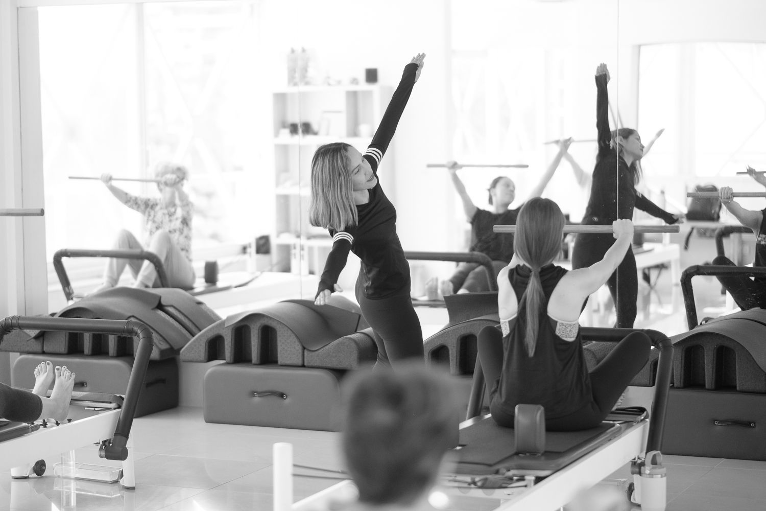 Un grupo de personas está haciendo ejercicios de pilates en un gimnasio.
