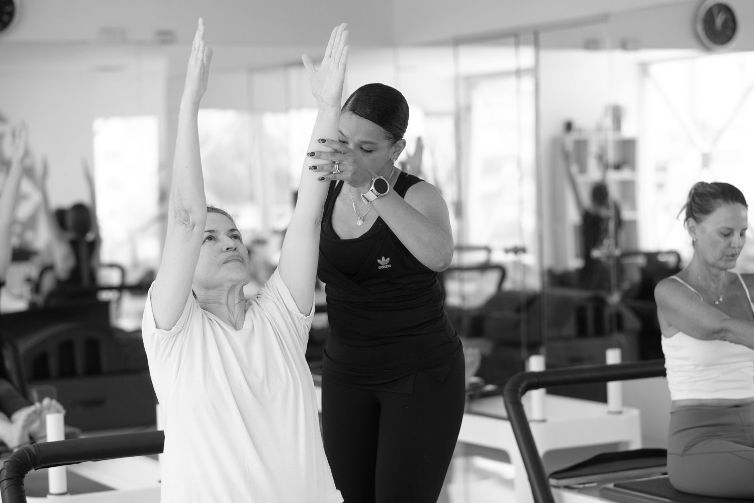 Un grupo de mujeres están haciendo yoga juntas en un gimnasio.