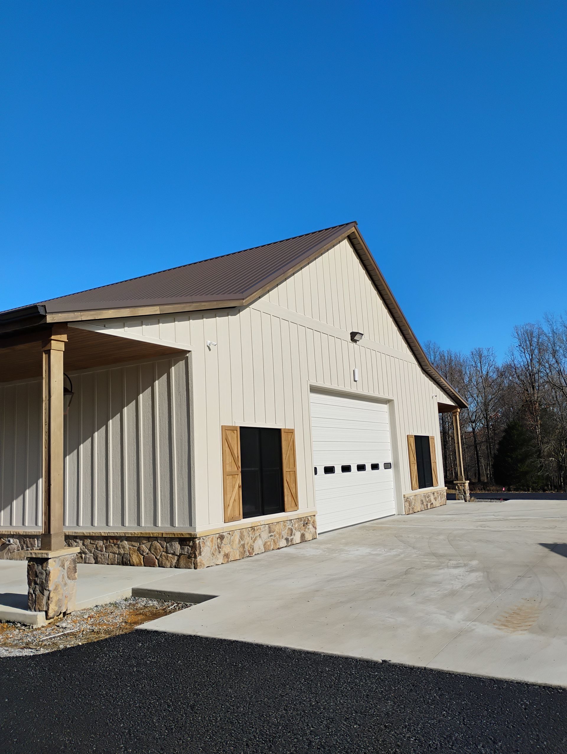 A white building with a brown roof and a white garage door