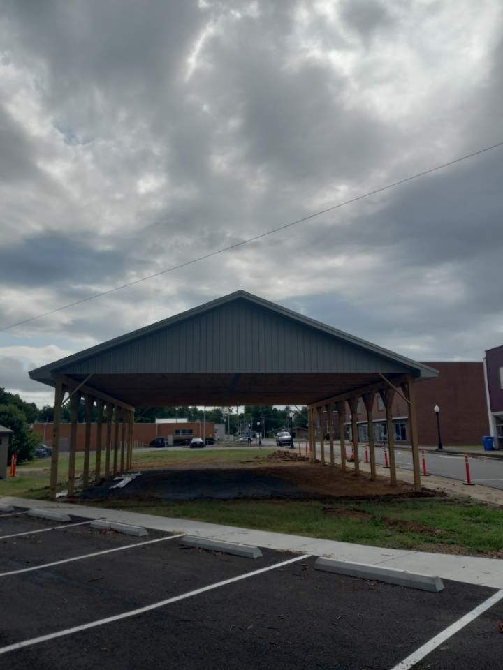 A carport is being built in a parking lot