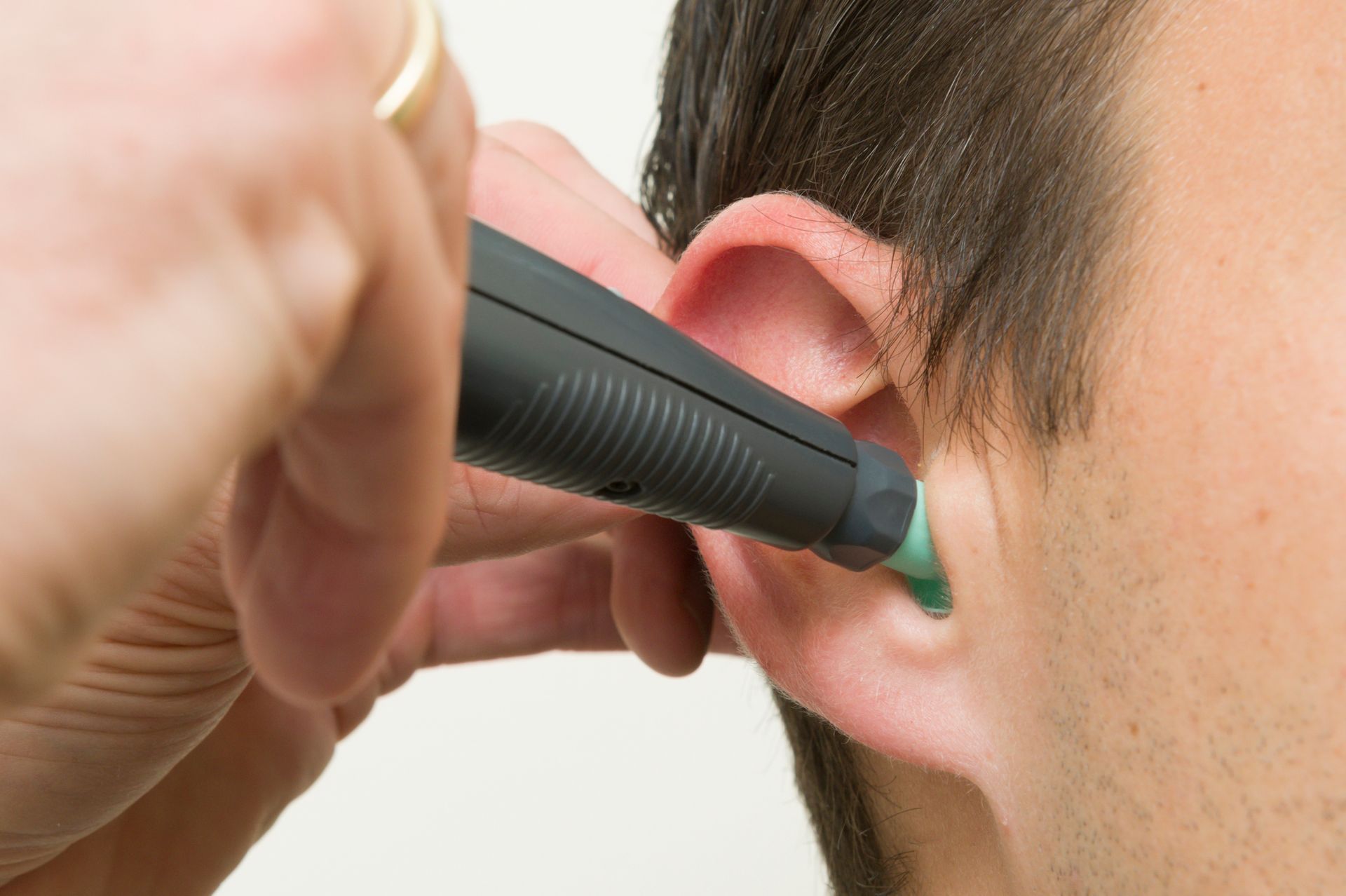 An ENT doctor examining a patient's ear before a micro-ear cleaning procedure An ENT doctor examining a patient's ear before a micro-ear cleaning procedure