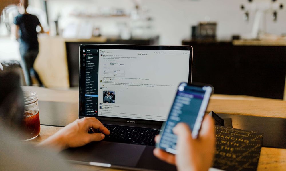 A person is using a laptop and a cell phone at the same time.