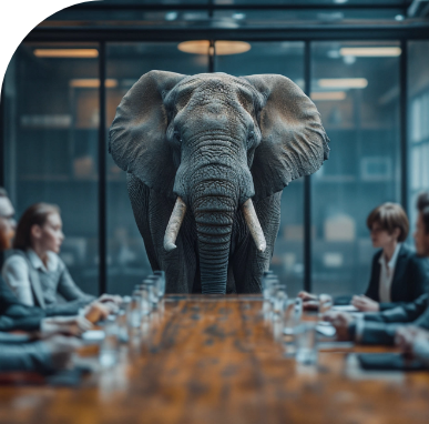 An elephant is standing on a long wooden table in front of a group of people.