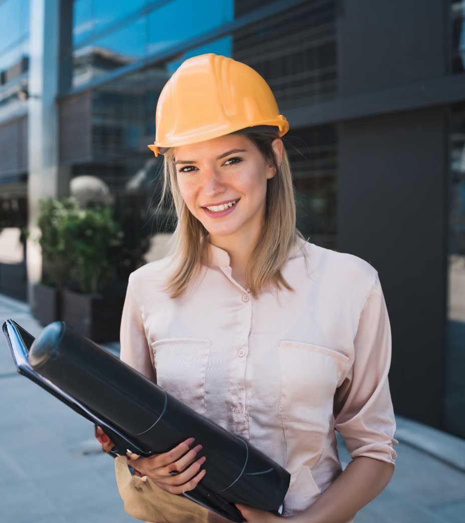 A woman wearing a hard hat is holding a blueprint.