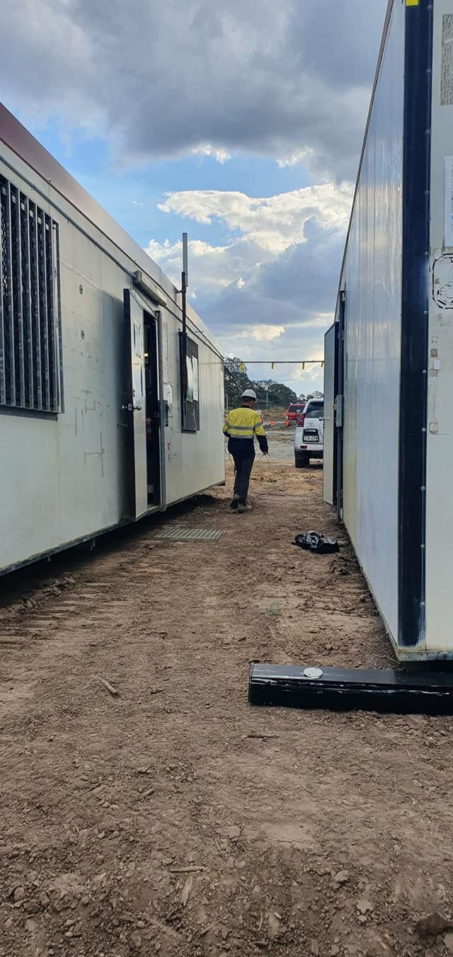 A Man is Walking Down a Dirt Path Between Two Buildings — D.J. Whatley & Son Pty Ltd in Beenleigh, QLD