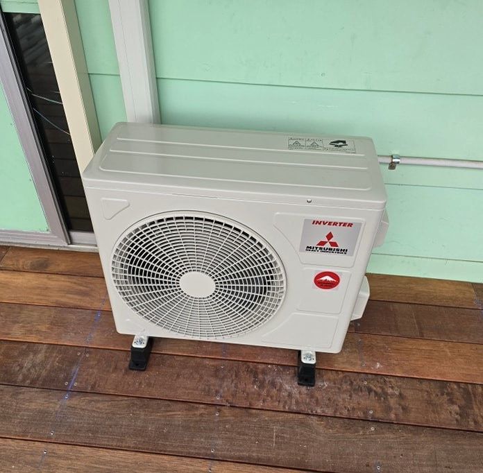 Mitsubishi Air Conditioner is Sitting on a Wooden Deck — D.J. Whatley & Son Pty Ltd in Beenleigh, QLD