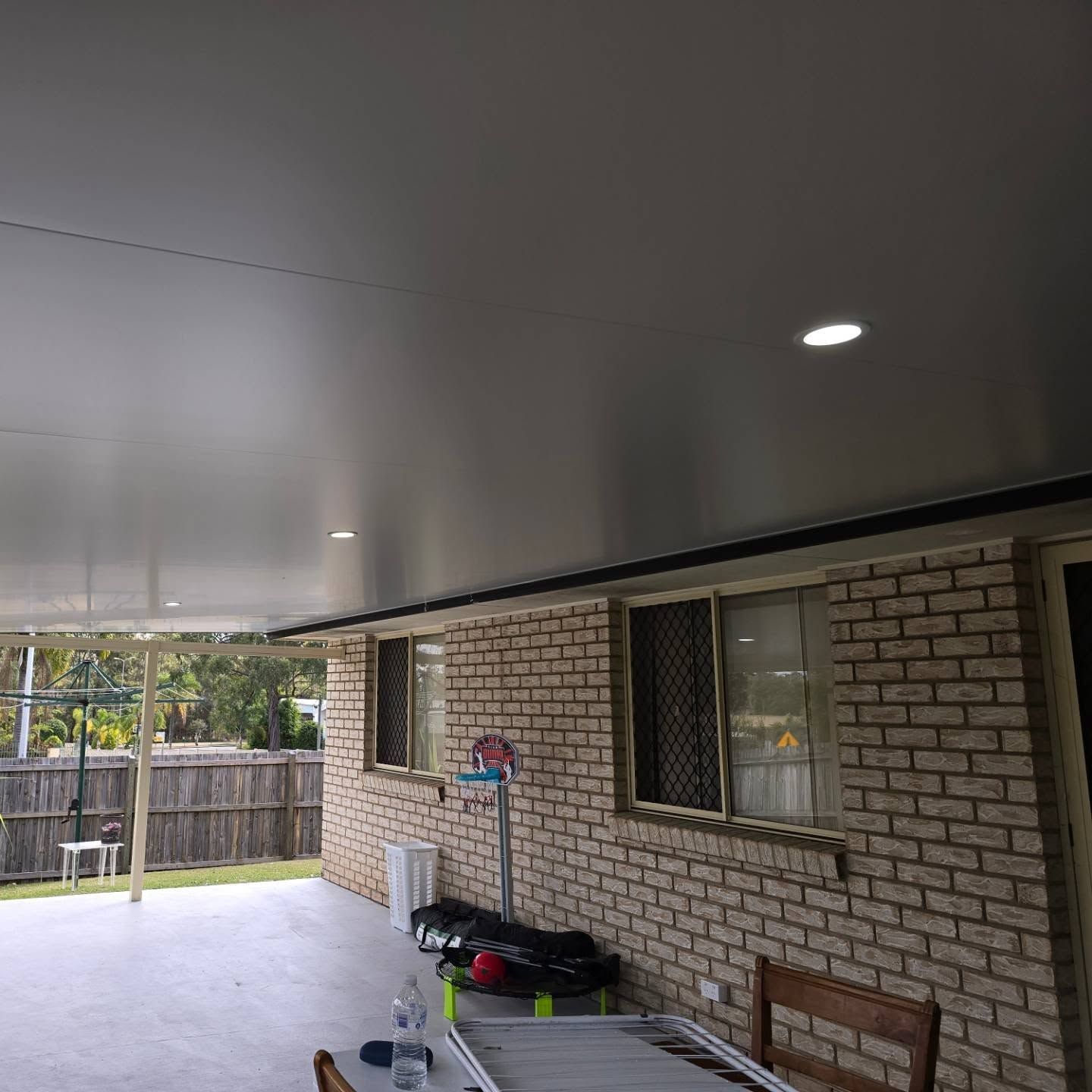 There is a table and chairs on the porch of a brick house. — D.J. Whatley & Son Pty Ltd in Yatala, QLD