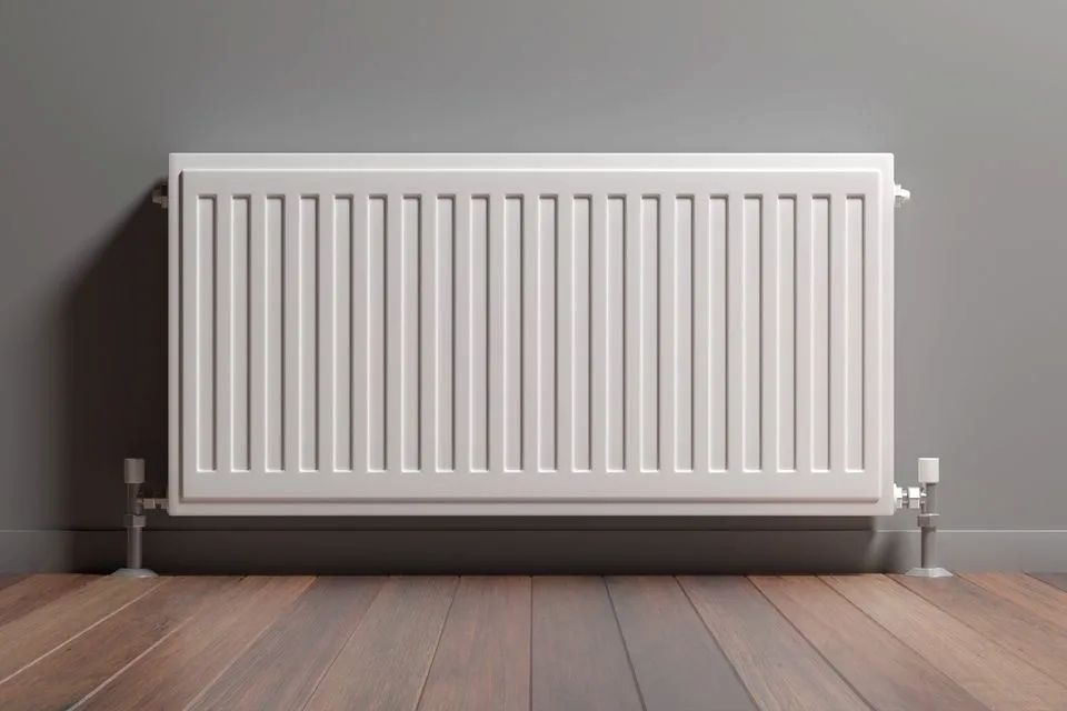 A White Radiator is Sitting on a Wooden Floor in a Room — D.J. Whatley & Son Pty Ltd in Pimpama, QLD
