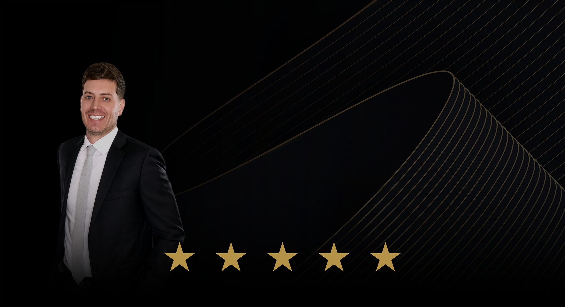 Smiling man in a black suit beside five gold stars on a dark background