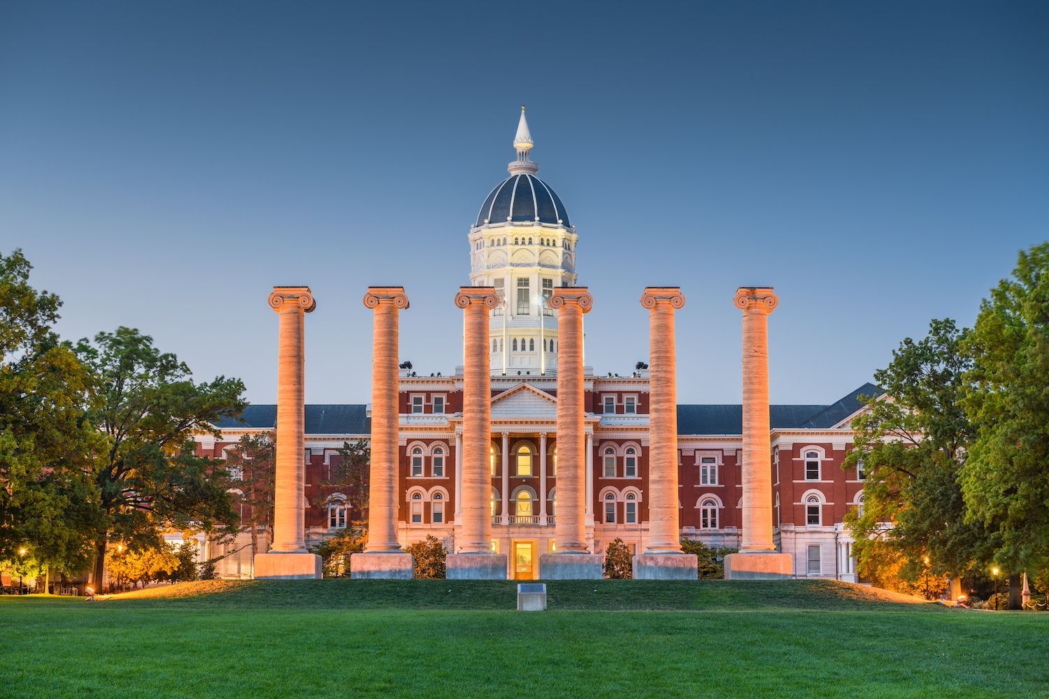 The six stone columns of the University of Missouri’s Francis Quadrangle in front of Jesse Hall at twilight.