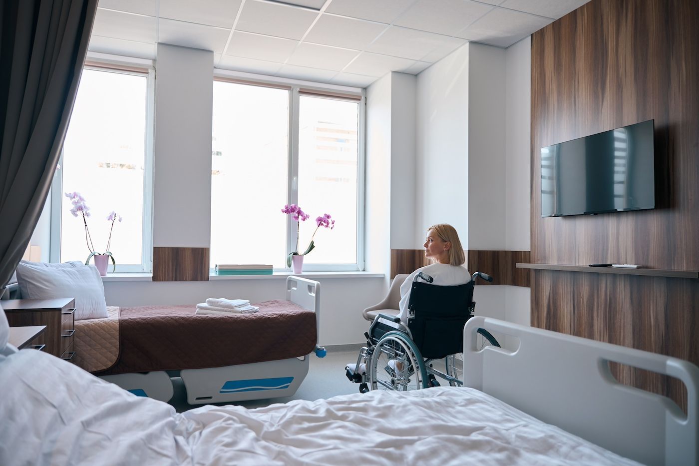 A Woman Sits In A Wheelchair In A Hospital Room After A Personal Injury. Contact Duckworth Injury Law.