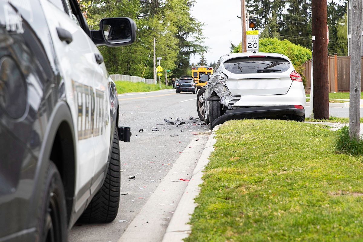 A Sheriff’s Car Sits Behind a Silver Car After a Mid-MO Car Accident. Call Duckworth Injury Law.